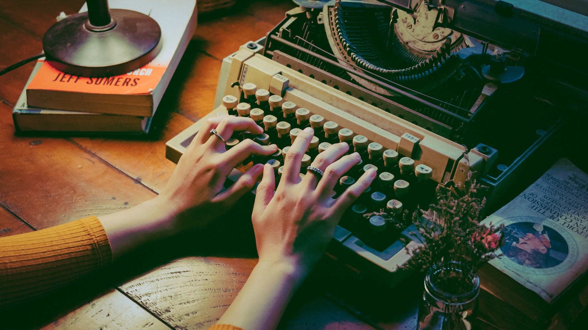 An image of a writer typing in a typewriter