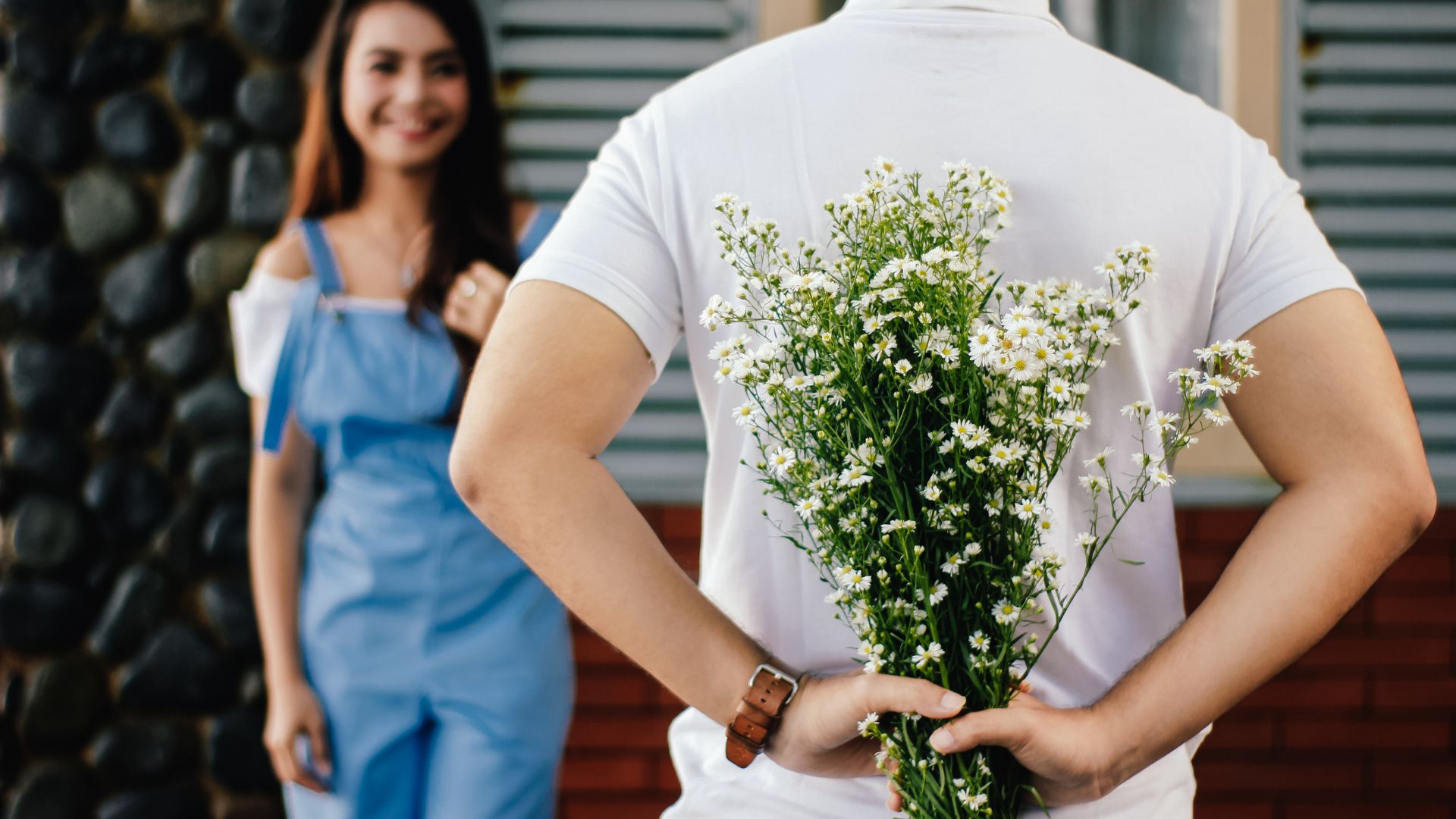 a person offering flowers to a girl