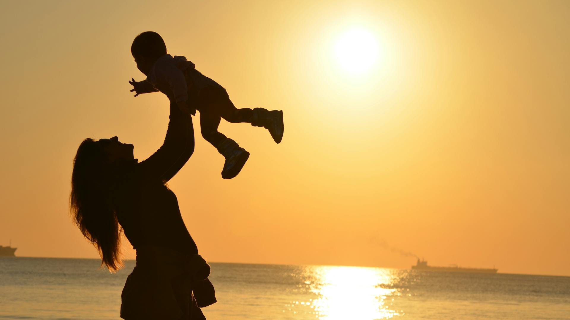 A person lifting a baby